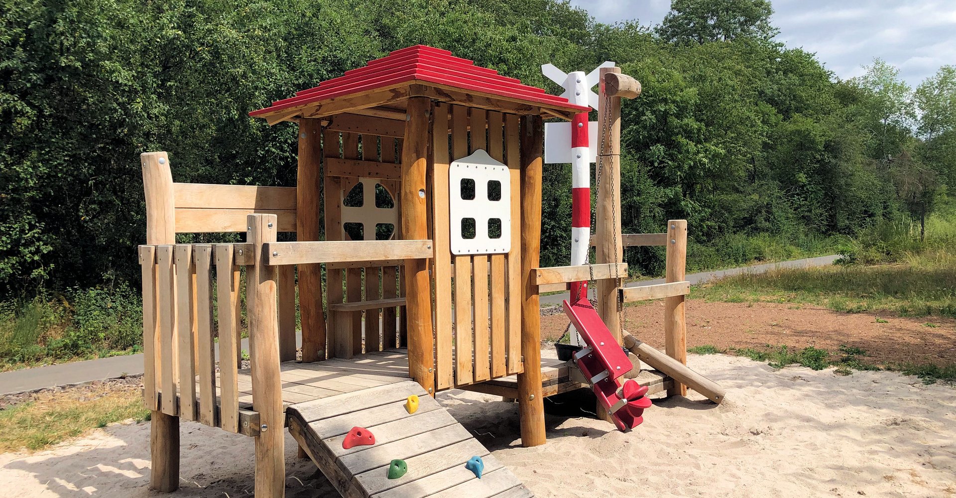 Spielgerät aus Holz, das einen Bahnhof symbolisiert