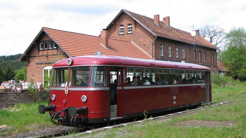 © Marcus Ruch Einfahrt der Hochwaldbahn in den Bahnhof Nonnweiler. Der Museumszug steht auf den Gleisen vor dem Bahnhofsgebäude des Bahnhofs Nonnweiler. Im Vordergrund des Bildes ist grüne Wiese zu sehen