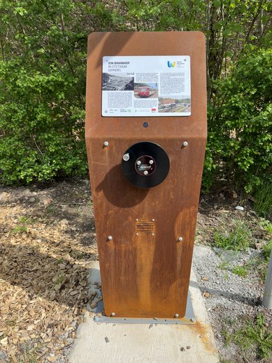 Eine Mediasäule steht am Rande des Bahnradwegs